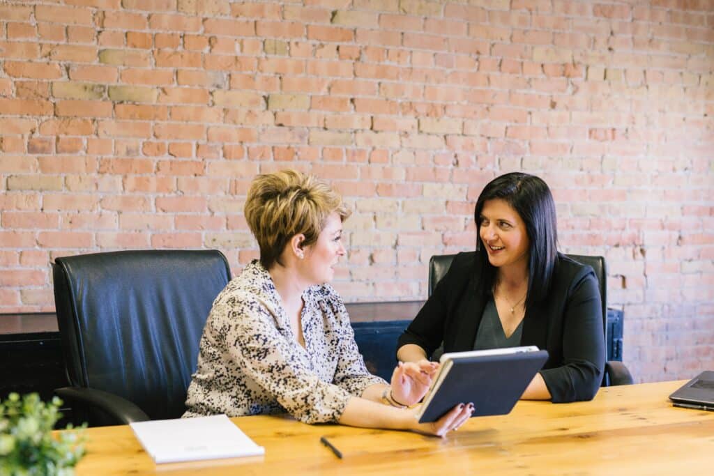 Two women working collaboratively in an office setting.