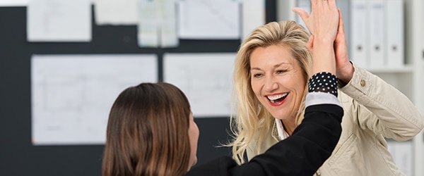 Two women in an office giving each other a high five - employee strengths