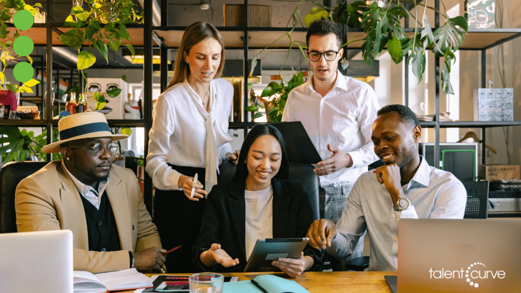 An image of 5 individuals with different ethnicities at an office representing workplace diversity.